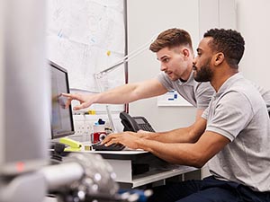 Male engineers working with a factory machine